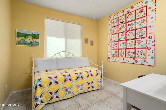 tiled bedroom featuring baseboards and ceiling fan