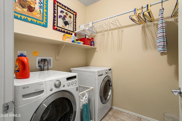 clothes washing area featuring laundry area, baseboards, independent washer and dryer, and light tile patterned floors