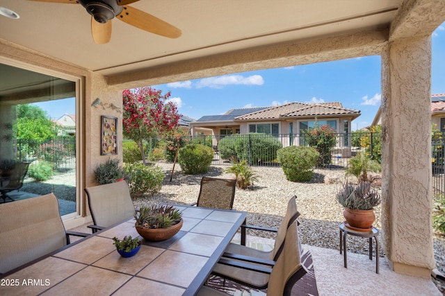 view of patio featuring a ceiling fan, outdoor dining area, and a fenced backyard