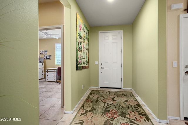 entryway with light tile patterned floors, ceiling fan, and baseboards
