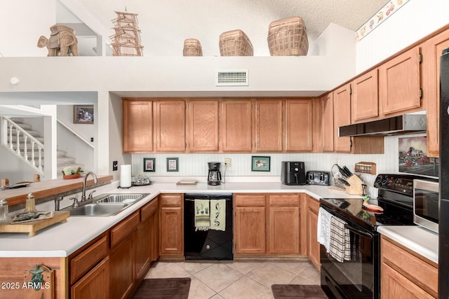 kitchen featuring a towering ceiling, light tile patterned floors, sink, and black appliances