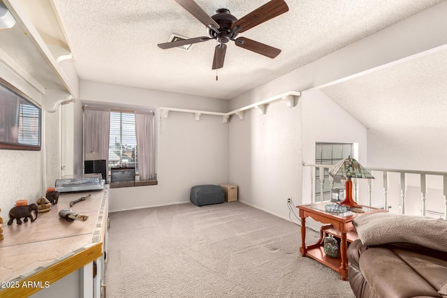 interior space featuring ceiling fan, carpet floors, a textured ceiling, and lofted ceiling