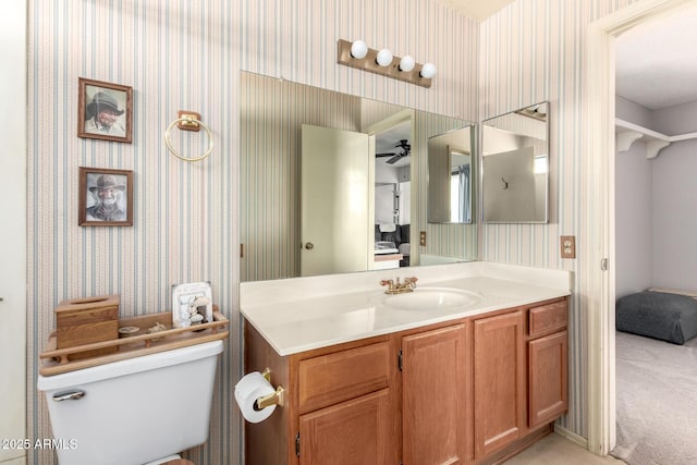 bathroom featuring vanity, toilet, and ceiling fan