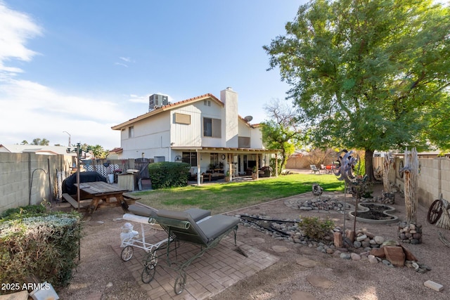 rear view of property featuring a lawn, a patio area, and central AC