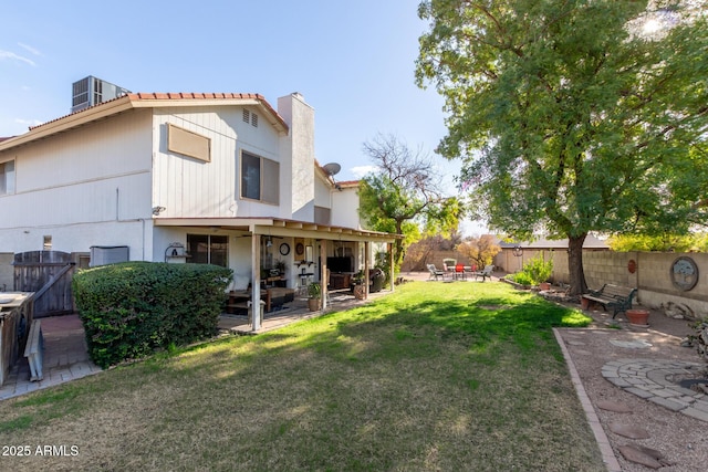 rear view of property featuring a patio and a lawn