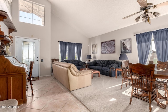 living room with ceiling fan, high vaulted ceiling, and light tile patterned flooring