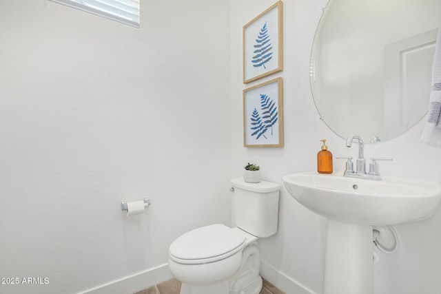 bathroom featuring baseboards and toilet