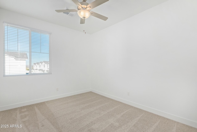 spare room featuring baseboards, light colored carpet, and a ceiling fan