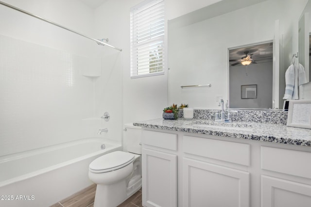 full bath featuring ceiling fan, toilet, vanity, tub / shower combination, and wood finished floors