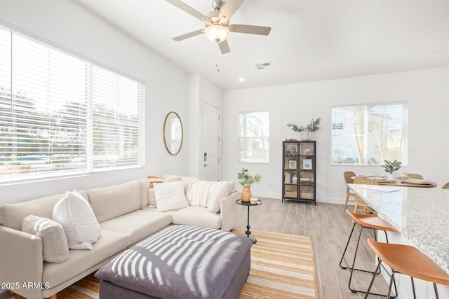 living room featuring ceiling fan, light wood finished floors, baseboards, and recessed lighting