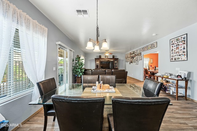 dining space with a chandelier and wood-type flooring