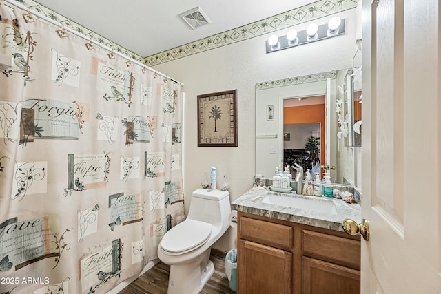 bathroom with toilet, vanity, curtained shower, and hardwood / wood-style floors