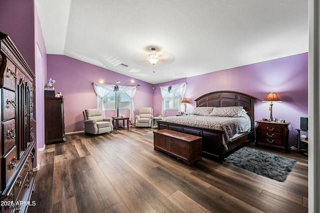 bedroom with ceiling fan, dark wood-type flooring, and lofted ceiling