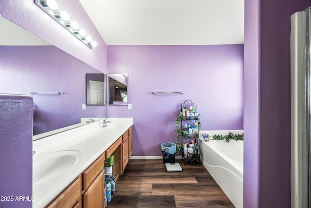 bathroom with vanity, a bathtub, and wood-type flooring