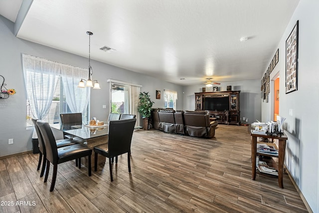 dining room with ceiling fan with notable chandelier and a healthy amount of sunlight