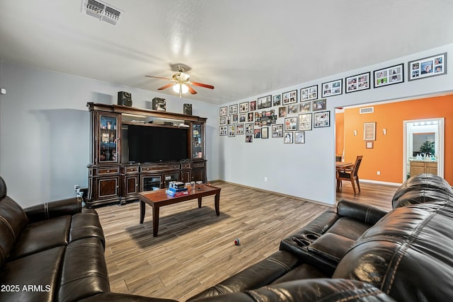 living room featuring ceiling fan and light hardwood / wood-style flooring