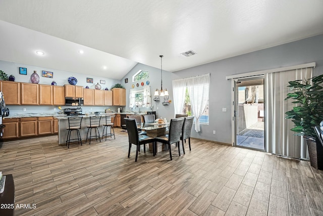 dining room with vaulted ceiling and an inviting chandelier