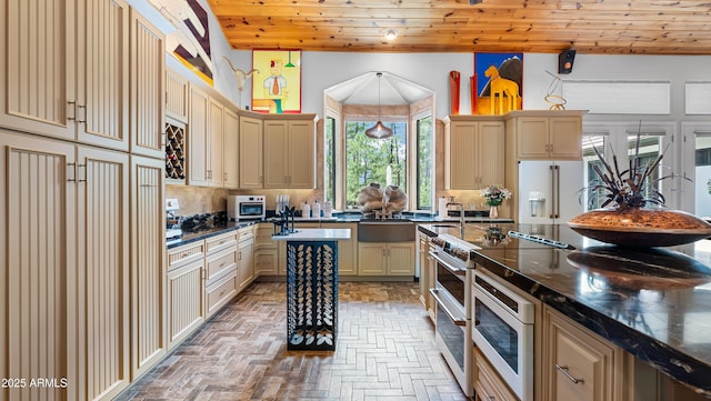 kitchen with backsplash, high end white refrigerator, wooden ceiling, cream cabinetry, and range with two ovens