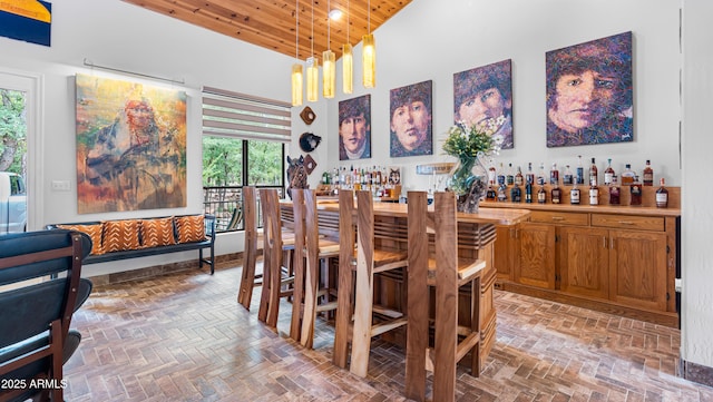 dining room featuring high vaulted ceiling, a healthy amount of sunlight, a dry bar, and wood ceiling