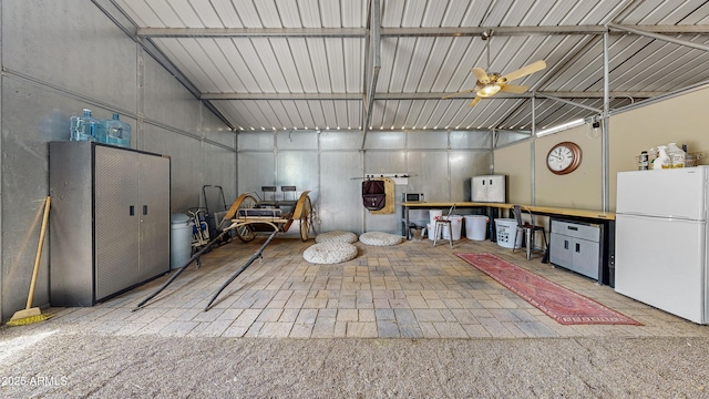 garage featuring a ceiling fan and freestanding refrigerator