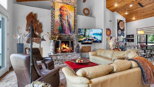 living area featuring high vaulted ceiling, a stone fireplace, wood ceiling, and recessed lighting