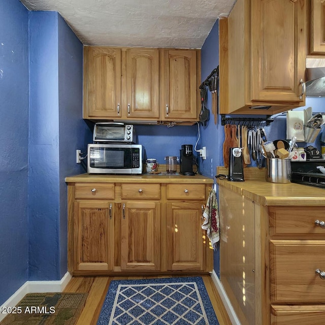 kitchen featuring a textured ceiling and wood-type flooring