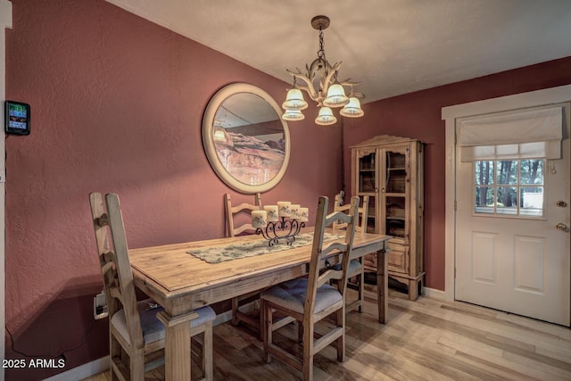 dining area featuring light hardwood / wood-style floors and an inviting chandelier