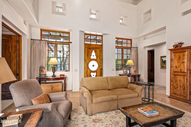 living room featuring tile flooring and a towering ceiling