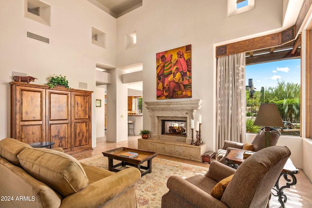 living room with a towering ceiling and light tile flooring