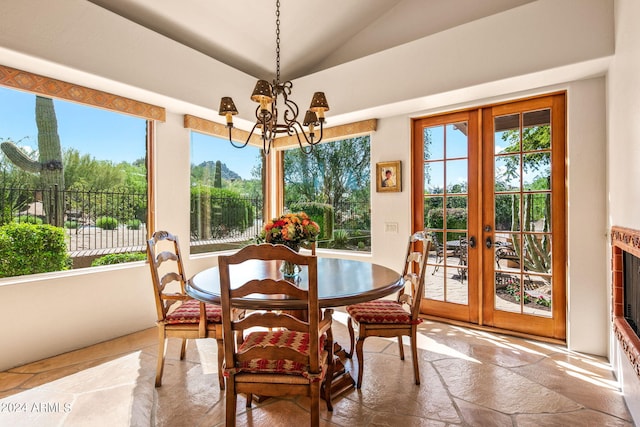 sunroom with french doors, a notable chandelier, and vaulted ceiling