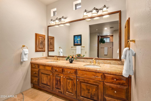 bathroom with tile flooring, dual sinks, and oversized vanity