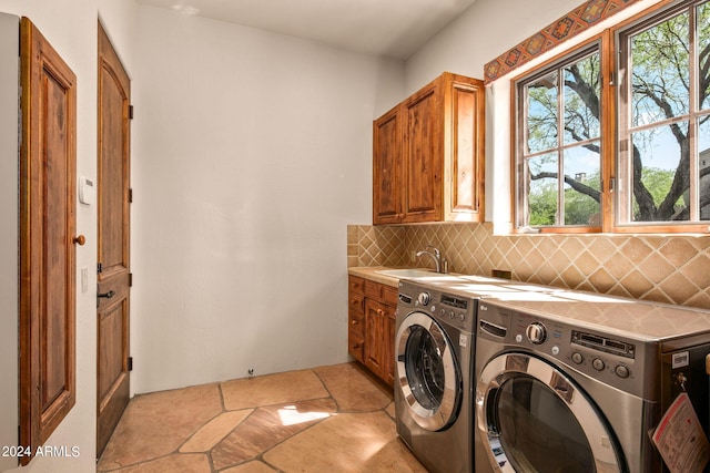 laundry room with cabinets, washer and clothes dryer, light tile floors, and sink