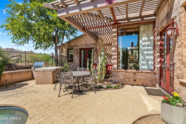 view of terrace featuring french doors, a pergola, and an outdoor kitchen