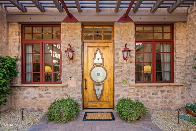 entrance to property featuring a pergola