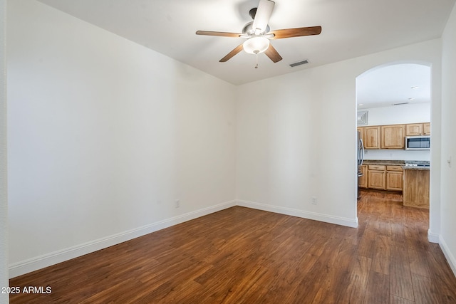 1031 W Longhorn Dr, Chandler, AZ 85286 - spare room with arched walkways, dark wood-style floors, a ceiling fan, and baseboards