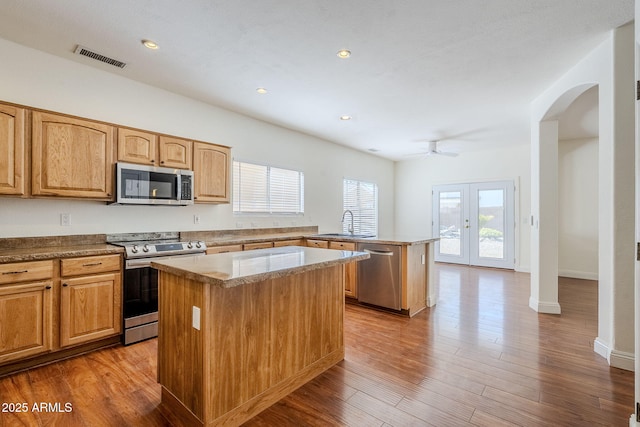 1031 W Longhorn Dr, Chandler, AZ 85286 - kitchen with appliances with stainless steel finishes, a sink, a center island, a peninsula, and arched walkways