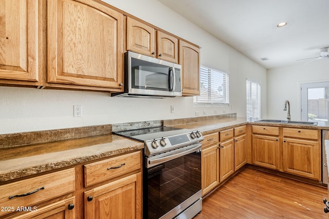 1031 W Longhorn Dr, Chandler, AZ 85286 - kitchen featuring appliances with stainless steel finishes, a sink, light wood finished floors, plenty of natural light, and recessed lighting