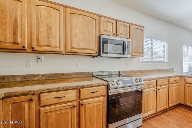 1031 W Longhorn Dr, Chandler, AZ 85286 - kitchen featuring stainless steel appliances, light wood finished floors, light countertops, and light brown cabinetry