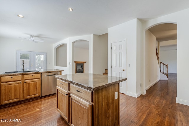 1031 W Longhorn Dr, Chandler, AZ 85286 - kitchen featuring dishwasher, a ceiling fan, arched walkways, wood finished floors, and a sink
