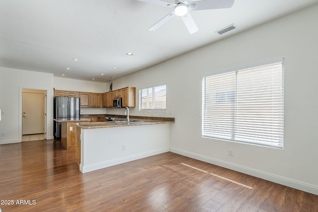 1031 W Longhorn Dr, Chandler, AZ 85286 - kitchen featuring wood finished floors, a peninsula, stainless steel appliances, baseboards, and recessed lighting