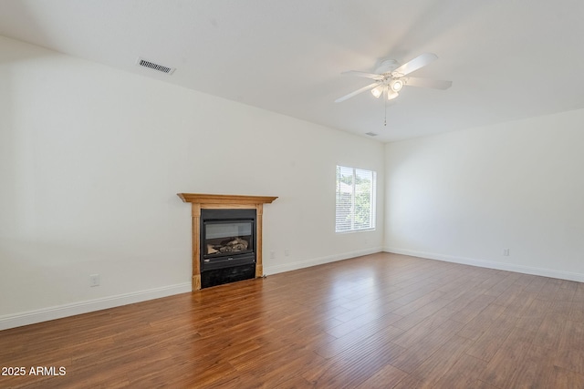 1031 W Longhorn Dr, Chandler, AZ 85286 - unfurnished living room with ceiling fan, wood finished floors, baseboards, and a glass covered fireplace