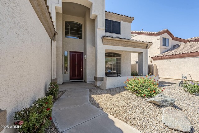 1031 W Longhorn Dr, Chandler, AZ 85286 - view of exterior entry with stucco siding, a tile roof, and a porch