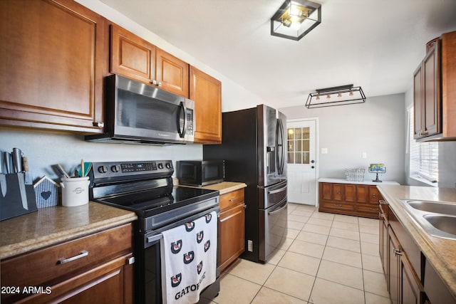 kitchen with light tile patterned floors, stainless steel appliances, and sink