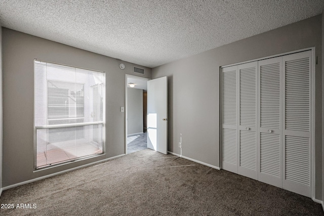 unfurnished bedroom featuring a closet, a textured ceiling, and carpet flooring