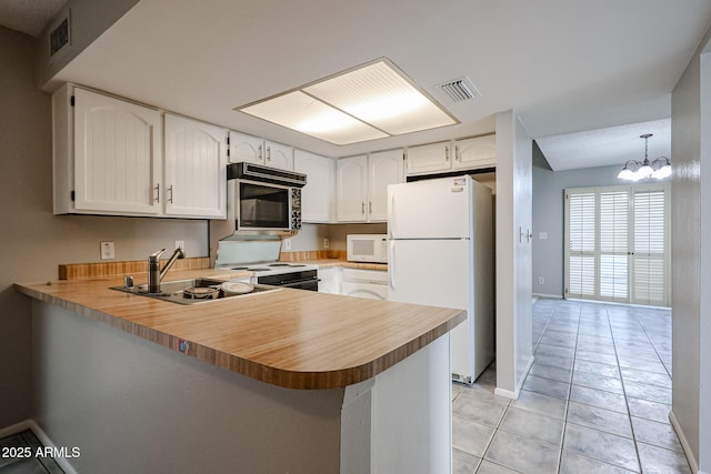 kitchen with white cabinetry, white appliances, decorative light fixtures, and kitchen peninsula