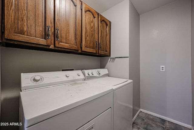 laundry area featuring cabinets, washer and dryer, and dark tile patterned flooring