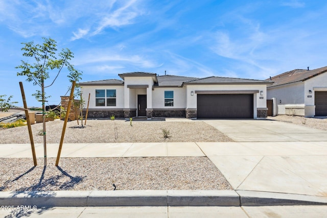 15349 W Cottontail Ln, Surprise, AZ 85387 - prairie-style home with stone siding, a garage, concrete driveway, and stucco siding