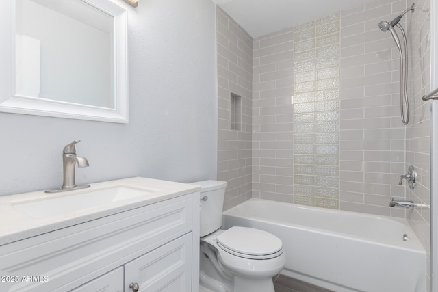 full bathroom featuring tiled shower / bath combo, vanity, and toilet