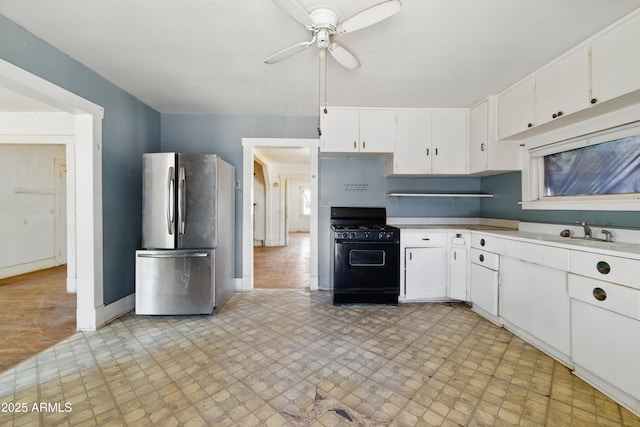 5901 E Short Ave, Globe, AZ 85501 - kitchen featuring freestanding refrigerator, black gas range oven, ceiling fan, white cabinets, and light countertops