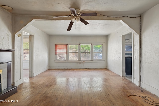 5901 E Short Ave, Globe, AZ 85501 - unfurnished living room with hardwood / wood-style flooring, a fireplace with raised hearth, and a ceiling fan